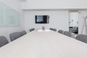 团队会议室内讨论乐玩体育产品方向的场景，桌面摆着笔记本，氛围专注